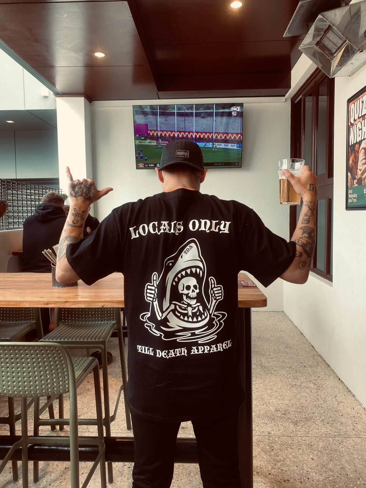Black LOCALS ONLY T-shirt worn from the back