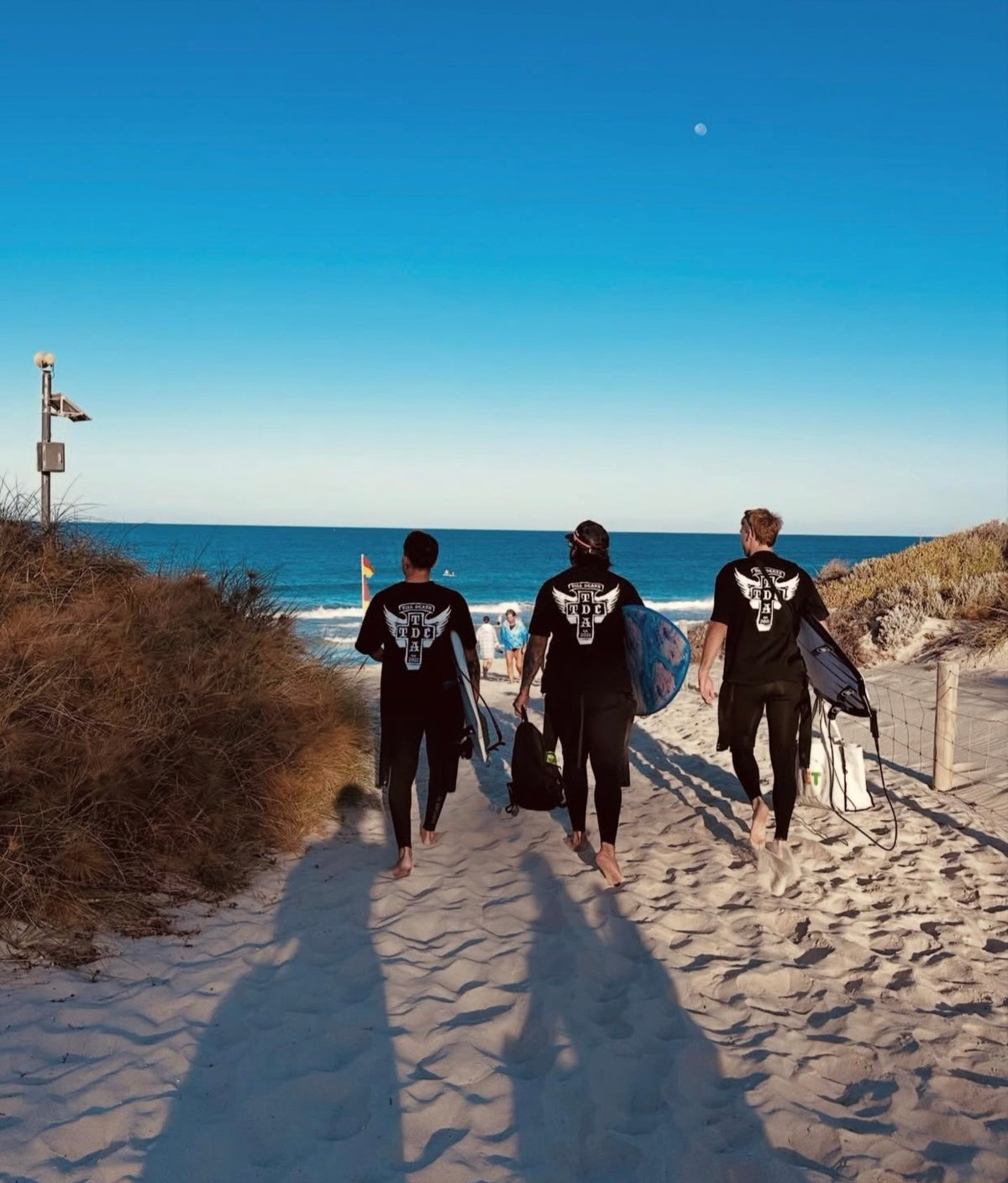 Till Death Apparel crew walking towards the beach with boards